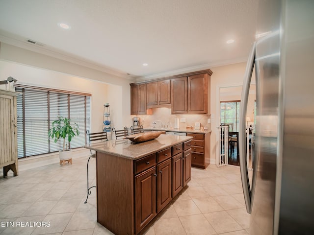 1201 Bentley Park Ln, Knoxville, TN 37922 - kitchen with freestanding refrigerator, a kitchen breakfast bar, light tile patterned flooring, an island with sink, and light stone counters