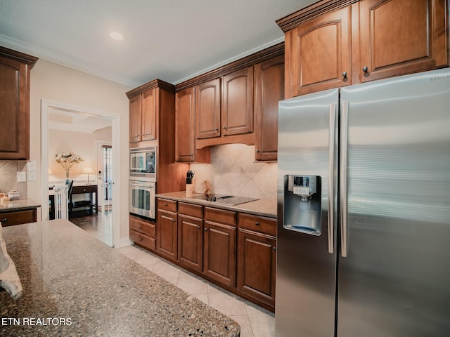 1201 Bentley Park Ln, Knoxville, TN 37922 - kitchen featuring appliances with stainless steel finishes, dark stone counters, tasteful backsplash, light tile patterned floors, and ornamental molding