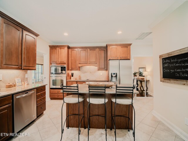 1201 Bentley Park Ln, Knoxville, TN 37922 - kitchen featuring appliances with stainless steel finishes, light stone counters, tasteful backsplash, a breakfast bar area, and recessed lighting