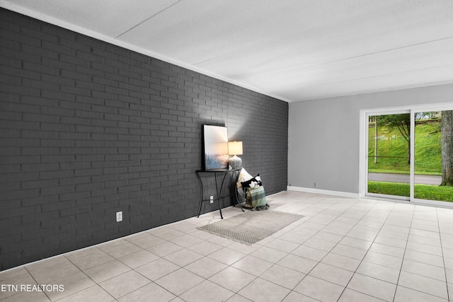 467 Canberra Dr Unit B103, Knoxville, TN 37923 - empty room featuring brick wall, light tile patterned floors, a textured ceiling, and baseboards