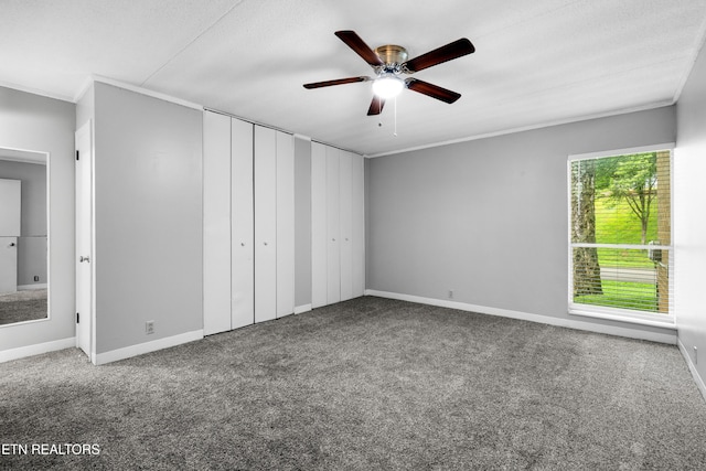 467 Canberra Dr Unit B103, Knoxville, TN 37923 - unfurnished bedroom featuring carpet flooring, baseboards, crown molding, a ceiling fan, and two closets