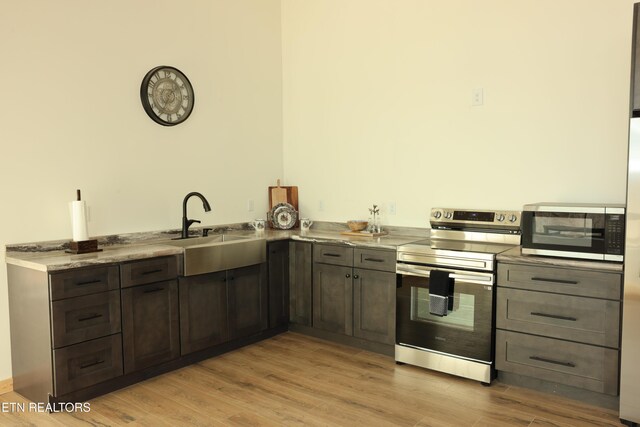 840 Ali Ln, Pvt, Huntsville, TN 37756 - kitchen featuring stainless steel appliances, a sink, light wood finished floors, and light stone countertops