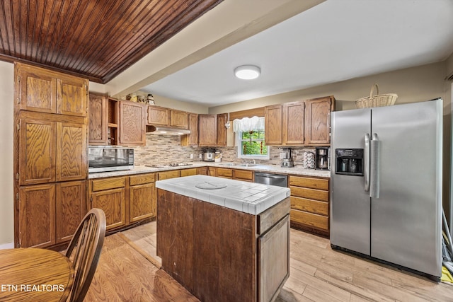 168 Boatman Rd, Cookeville, TN 38506 - kitchen with appliances with stainless steel finishes, under cabinet range hood, light wood-type flooring, tile counters, and decorative backsplash