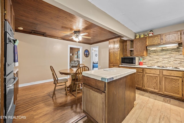 168 Boatman Rd, Cookeville, TN 38506 - kitchen with stainless steel appliances, tile counters, light wood-style flooring, under cabinet range hood, and wooden ceiling