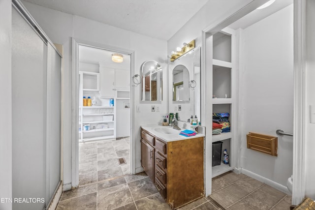 168 Boatman Rd, Cookeville, TN 38506 - bathroom featuring vanity, a stall shower, baseboards, stone finish flooring, and toilet