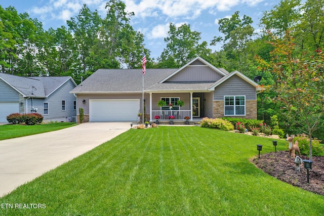 247 Thrushwood Dr, Fairfield Glade, TN 38558 - view of front of home featuring a porch, an attached garage, driveway, a front yard, and stone siding
