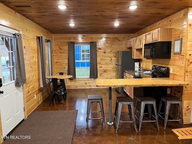 138 Matthews Rd, Oneida, TN 37841 - kitchen with black appliances, concrete floors, wood walls, wooden ceiling, and a breakfast bar area