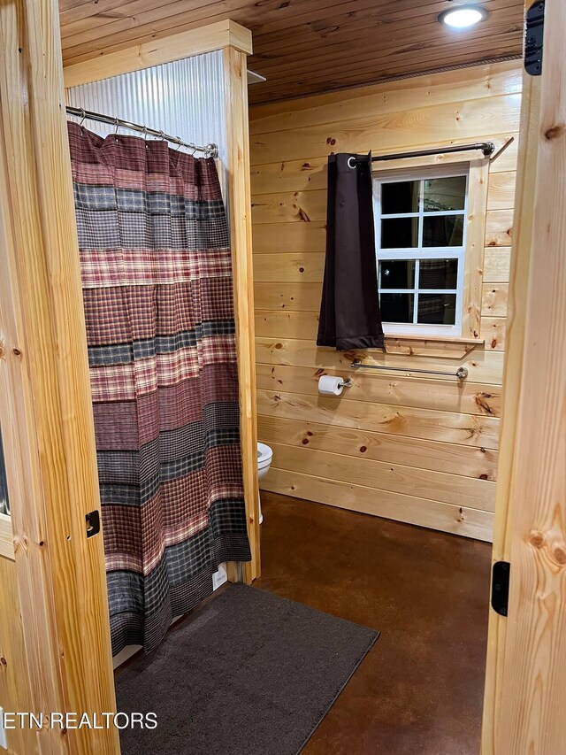 138 Matthews Rd, Oneida, TN 37841 - full bathroom featuring finished concrete flooring, wooden walls, toilet, and a shower with shower curtain
