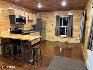 138 Matthews Rd, Oneida, TN 37841 - kitchen featuring stainless steel appliances, wooden ceiling, a breakfast bar area, wood walls, and a peninsula