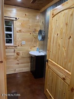 138 Matthews Rd, Oneida, TN 37841 - bathroom with wooden walls, wood ceiling, vanity, and concrete flooring