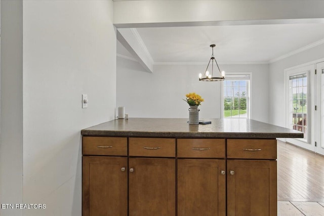 262 Cresent St, Harrogate, TN 37752 - kitchen featuring a peninsula, ornamental molding, brown cabinets, a chandelier, and pendant lighting