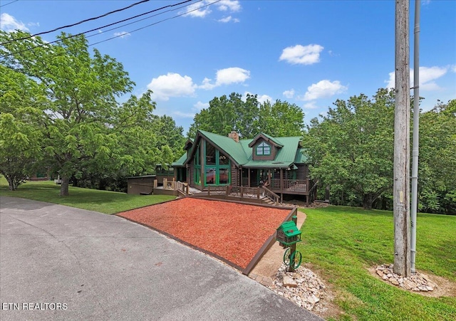 158 Dillon Rd, Baxter, TN 38544 - view of front facade featuring metal roof, a front lawn, a chimney, and view of wooded area