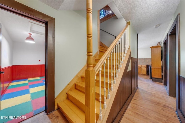 158 Dillon Rd, Baxter, TN 38544 - stairs with wainscoting, a textured ceiling, wood finished floors, and wood walls