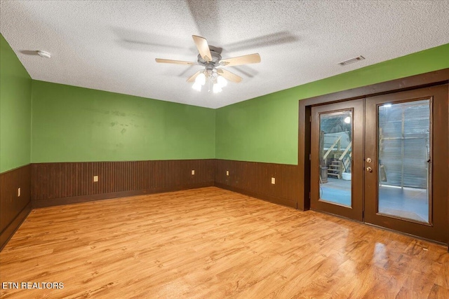 158 Dillon Rd, Baxter, TN 38544 - unfurnished room with french doors, wood finished floors, a wainscoted wall, a textured ceiling, and a ceiling fan