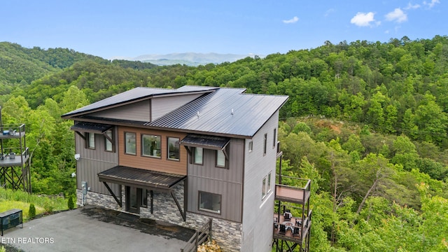 2955 Lightning Strike Dr, Sevierville, TN 37862 - view of front of home with a forest view, stone siding, metal roof, and driveway