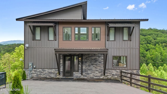 2955 Lightning Strike Dr, Sevierville, TN 37862 - view of front of house with stone siding, board and batten siding, and a forest view