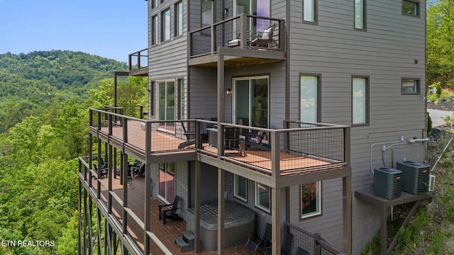 2955 Lightning Strike Dr, Sevierville, TN 37862 - back of house with a balcony, a forest view, a hot tub, and central AC unit