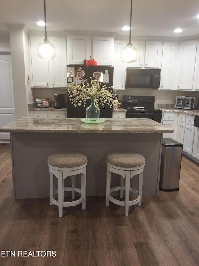 1748 Circle Lake Dr, Dandridge, TN 37725 - kitchen with black appliances, white cabinets, a kitchen breakfast bar, dark wood-type flooring, and pendant lighting