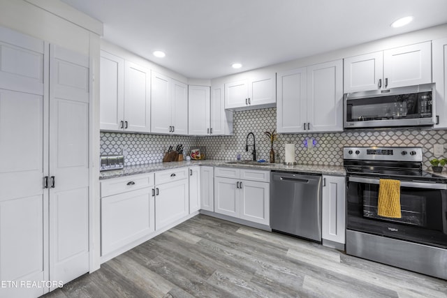 4509 Lifford Ln, Corryton, TN 37721 - kitchen with appliances with stainless steel finishes, a sink, light stone counters, white cabinets, and recessed lighting