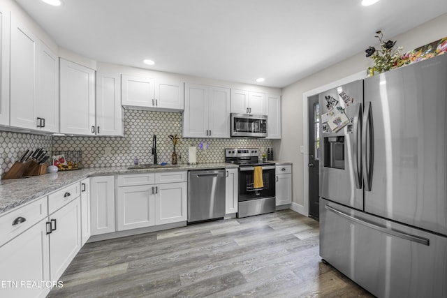 4509 Lifford Ln, Corryton, TN 37721 - kitchen with appliances with stainless steel finishes, a sink, tasteful backsplash, white cabinetry, and recessed lighting