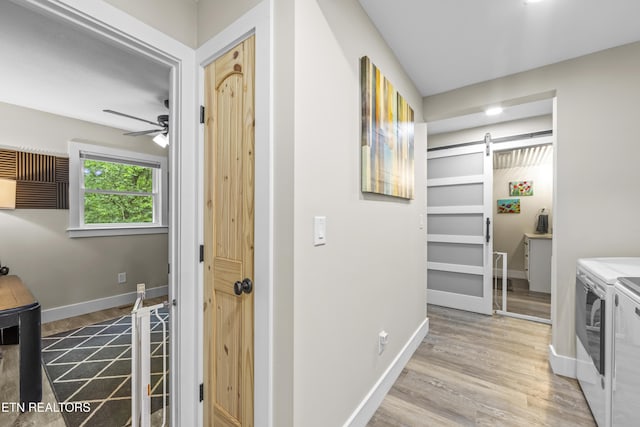 4509 Lifford Ln, Corryton, TN 37721 - laundry room with a barn door, washer and dryer, baseboards, and wood finished floors