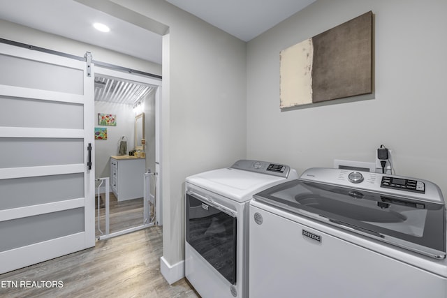 4509 Lifford Ln, Corryton, TN 37721 - laundry room featuring washing machine and clothes dryer, light wood-type flooring, and a barn door