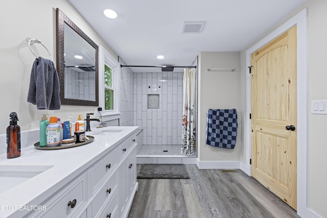 4509 Lifford Ln, Corryton, TN 37721 - full bath with a tile shower, wood finished floors, double vanity, recessed lighting, and baseboards