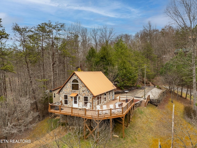 3325 Tekoa Mountain Way, Sevierville, TN 37876 - back of property featuring stone siding, a deck, metal roof, and a wooded view