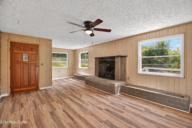 2594 Indian Creek Rd, Thorn Hill, TN 37881 - unfurnished living room featuring ceiling fan, a textured ceiling, wood finished floors, plenty of natural light, and a fireplace