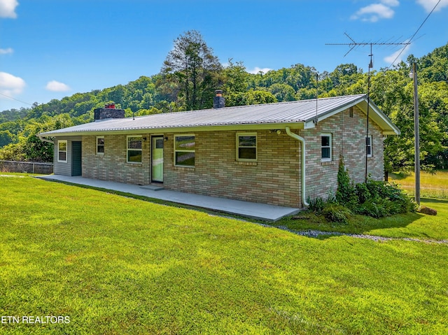 2594 Indian Creek Rd, Thorn Hill, TN 37881 - rear view of house featuring a patio area, a chimney, brick siding, and a metal roof