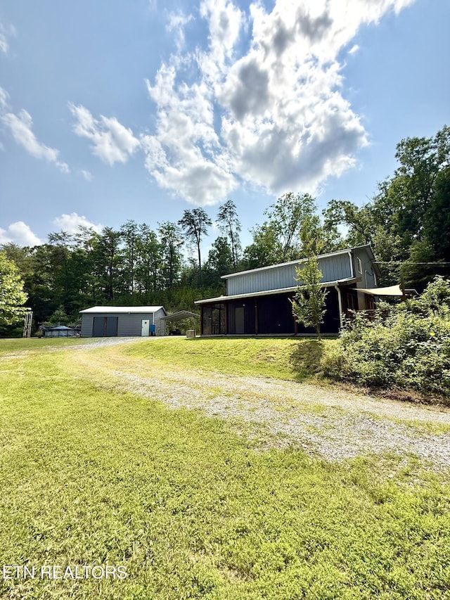 179 Wiggins Rd, Tellico Plains, TN 37385 - view of green lawn with driveway and an outbuilding