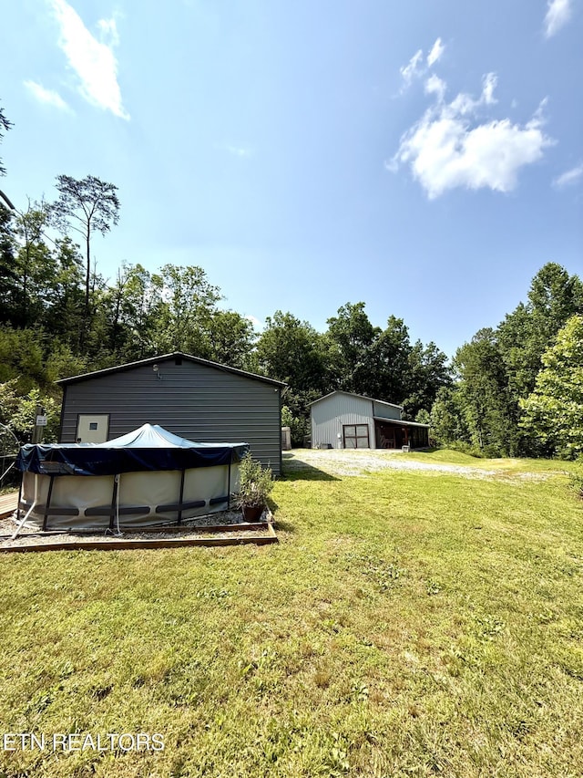 179 Wiggins Rd, Tellico Plains, TN 37385 - view of grassy yard with an outdoor structure and a garage