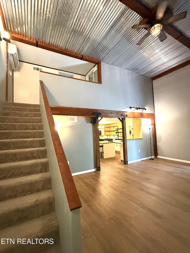179 Wiggins Rd, Tellico Plains, TN 37385 - stairway with ceiling fan, wood finished floors, baseboards, and an AC wall unit