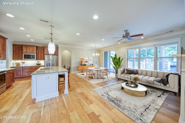 126 Pocola Way, Loudon, TN 37774 - kitchen with stainless steel appliances, crown molding, ceiling fan, brown cabinets, and a kitchen bar