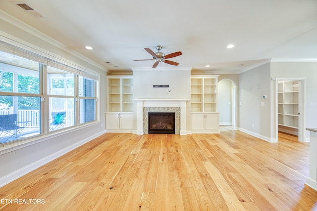 126 Pocola Way, Loudon, TN 37774 - unfurnished living room with crown molding, ceiling fan, arched walkways, light wood-style floors, and a glass covered fireplace