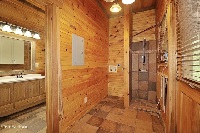 495 Bear Hollow Rd, Oneida, TN 37841 - full bath with electric panel, vanity, a tile shower, wood walls, and stone finish floors