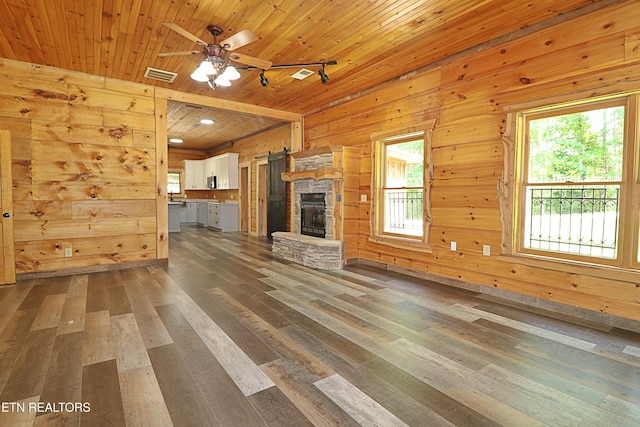495 Bear Hollow Rd, Oneida, TN 37841 - unfurnished living room featuring dark wood-style floors, a ceiling fan, a stone fireplace, wood walls, and wooden ceiling