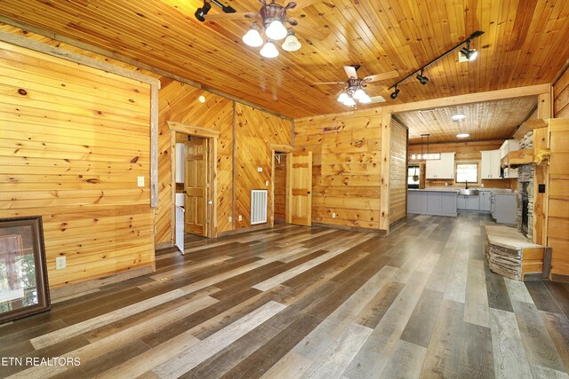 495 Bear Hollow Rd, Oneida, TN 37841 - unfurnished living room featuring rail lighting, wood walls, a ceiling fan, a sink, and dark wood-style flooring