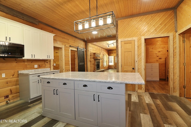 495 Bear Hollow Rd, Oneida, TN 37841 - kitchen with wood walls, wood ceiling, wood finished floors, a barn door, and white cabinets