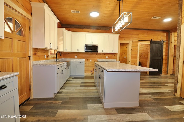 495 Bear Hollow Rd, Oneida, TN 37841 - kitchen with stainless steel microwave, a sink, a kitchen island, dark wood-style flooring, and wooden ceiling