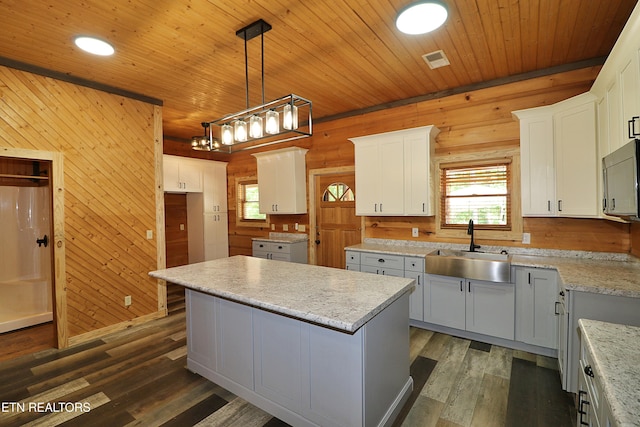 495 Bear Hollow Rd, Oneida, TN 37841 - kitchen featuring a sink, wood walls, a kitchen island, wood ceiling, and dark wood-type flooring