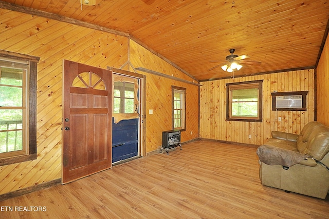 495 Bear Hollow Rd, Oneida, TN 37841 - unfurnished living room featuring vaulted ceiling, wooden walls, a wood stove, plenty of natural light, and wooden ceiling