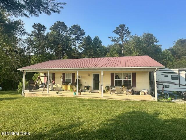 832 Fritzsche, Jamestown, TN 38556 - back of property featuring covered porch, a lawn, and metal roof