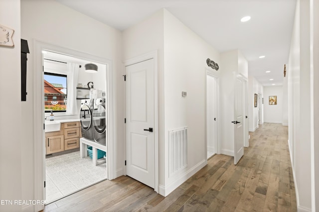 888 Smokey Quartz Blvd, New Tazewell, TN 37825 - corridor with washing machine and clothes dryer, light wood-type flooring, recessed lighting, a sink, and baseboards