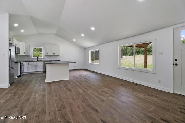 1095 Franklin Rd, Jamestown, TN 38556 - kitchen featuring appliances with stainless steel finishes, dark countertops, vaulted ceiling, open floor plan, and white cabinetry