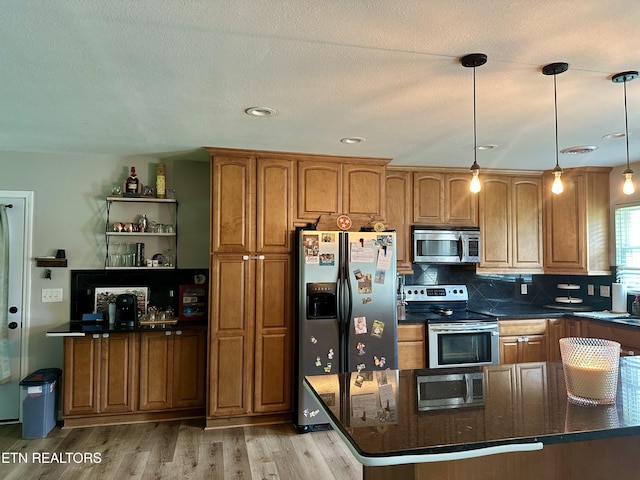 306 E Tri County Blvd, Oliver Springs, TN 37840 - kitchen featuring appliances with stainless steel finishes, brown cabinetry, light wood-style floors, and tasteful backsplash