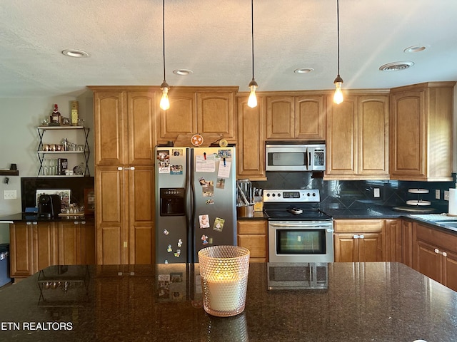306 E Tri County Blvd, Oliver Springs, TN 37840 - kitchen with appliances with stainless steel finishes, decorative backsplash, hanging light fixtures, brown cabinets, and dark stone countertops