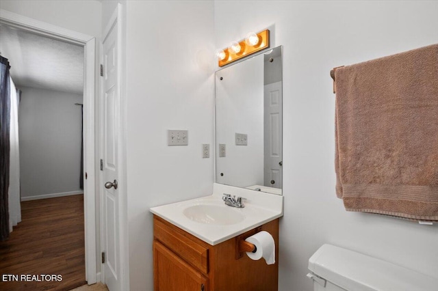 340 Mountain View Ests, Caryville, TN 37714 - half bathroom featuring vanity, toilet, baseboards, and wood finished floors