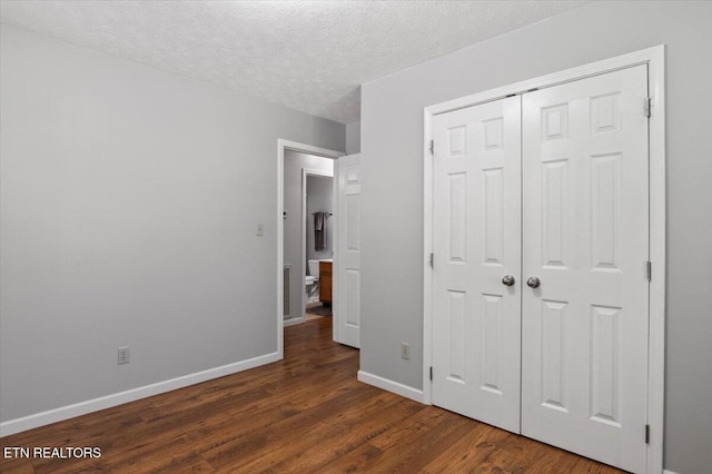 340 Mountain View Ests, Caryville, TN 37714 - unfurnished bedroom with dark wood-style floors, baseboards, a textured ceiling, and a closet