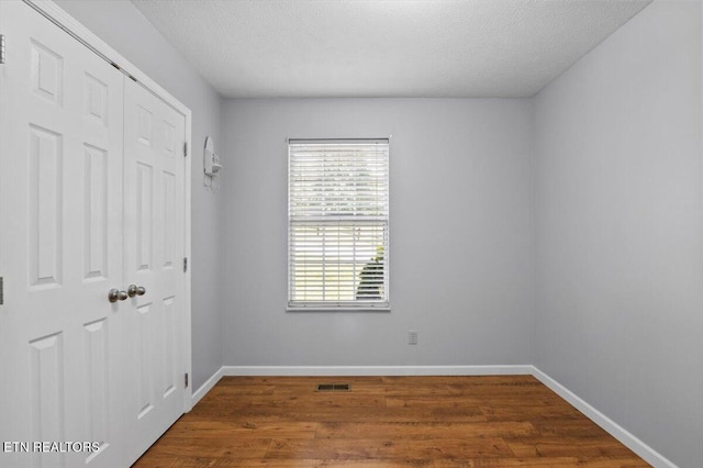 340 Mountain View Ests, Caryville, TN 37714 - unfurnished bedroom with baseboards, wood finished floors, a closet, and a textured ceiling